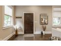 Bright and airy foyer featuring a decorative wooden door, hardwood floors, and stylish decor at 5254 N Park Ave, Indianapolis, IN 46220