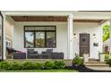 Inviting front porch with comfortable seating, elegant planters, and a beautifully stained front door at 5254 N Park Ave, Indianapolis, IN 46220