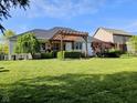 Outdoor patio with a stylish pergola, ideal for relaxing and entertaining, surrounded by a lush green lawn at 5347 Sampson Dr, Indianapolis, IN 46237
