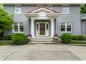 Inviting home entrance featuring a red-tile porch roof, stately columns, and a well-maintained lawn at 5430 N Washington Blvd, Indianapolis, IN 46220