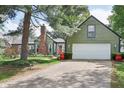 Charming exterior with green siding, white garage door, and well-maintained lawn and mature trees at 6210 Mckinley Ct, Indianapolis, IN 46220