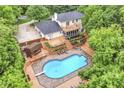 Aerial view of a backyard with a large swimming pool, deck and mature trees at 6530 Lowanna Way, Indianapolis, IN 46220