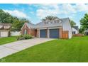 Side view of a brick home with a two-car garage and well-maintained landscaping at 6789 Passage Cir, Indianapolis, IN 46250