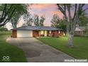 Charming red brick home with a metal roof, green door, and a well-maintained front yard at 679 Bark Dr, Anderson, IN 46011
