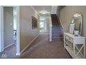 Welcoming foyer with staircase, carpeted floors, elegant console table, and neutral paint at 695 Overcup St, Westfield, IN 46074