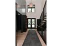Inviting foyer featuring a staircase, wood floors, chandelier, and front door at 7070 Dean Rd, Indianapolis, IN 46220