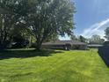 Expansive backyard with healthy lawn and mature trees provides ample space for recreation and relaxation at 7127 Lincoln St, Anderson, IN 46013