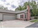 Exterior of home featuring a two-car garage, brick chimney, and well-maintained landscaping at 811 Gazebo Way, Greenwood, IN 46142