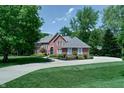 Beautiful two-story brick home featuring a well-manicured lawn, lush landscaping, and a basketball hoop at 9154 Sargent Manor Ct, Indianapolis, IN 46256