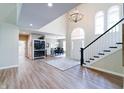 Bright foyer featuring hardwood floors, a chandelier, a staircase, and views into the dining room at 9154 Sargent Manor Ct, Indianapolis, IN 46256
