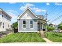 Charming home with manicured lawn, light blue siding, and a covered front porch at 1015 N Beville Ave, Indianapolis, IN 46201