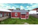 View of home exterior with red siding, white trim, and a well-maintained yard with green grass at 104 W Pearl St, Trafalgar, IN 46181