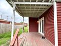 A side angle view of the covered porch with weathered wood decking and painted beams and supports at 104 W Pearl St, Trafalgar, IN 46181