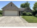 Charming brick home with attached garage and manicured lawn, offering curb appeal and functionality at 11014 Lake Run Dr, Fishers, IN 46038