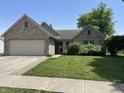 Charming brick home with attached garage and manicured lawn, offering curb appeal and functionality at 11014 Lake Run Dr, Fishers, IN 46038