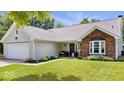 Attractive single-story house with a brick accent, a two-car garage, and a lush green lawn at 11041 Limbach Cir, Indianapolis, IN 46236