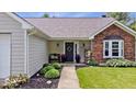 Inviting front entrance with a wreath, bench, and neatly arranged landscaping at 11041 Limbach Cir, Indianapolis, IN 46236