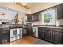 Well-lit kitchen with stainless steel appliances, dark cabinets, and hardwood floors at 11041 Limbach Cir, Indianapolis, IN 46236