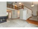 Open living room with staircase, fireplace, and an upstairs lofted landing, with dining area at 11051 Oakridge Dr, Fishers, IN 46038
