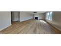 Spacious living room with wood-look flooring, fireplace, ceiling fan, and lots of natural light at 1305 Gleneagle Dr, Indianapolis, IN 46239