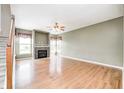 Spacious living room featuring hardwood floors, a fireplace, large windows and a ceiling fan at 1306 Flat Wood Ct, Brownsburg, IN 46112