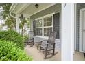 Charming front porch featuring rocking chairs, lush greenery, and stylish exterior details at 13817 Black Canyon Ct, Fishers, IN 46038
