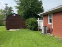 Well-kept backyard with a shed, central air conditioning unit, and green lawn at 1422 Dallas Dr, Plainfield, IN 46168