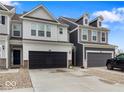 A row of townhomes, featuring varying neutral color schemes and black garage doors, are displayed in the exterior view at 14350 Ludwell Ct, Fishers, IN 46037