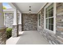 Covered front porch with stone pillars and exterior stone wall at 15292 Slateford Rd, Noblesville, IN 46062