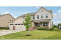 Charming two-story home featuring a three-car garage and well-manicured lawn at 15418 Tattersalls Ln, Fishers, IN 46040
