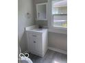 Cozy bathroom with a single sink vanity, mirror, and a window for natural light at 1820 S M St, Elwood, IN 46036