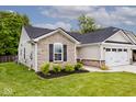 Side view of a well-maintained home with stone accents, a neat lawn, and an attached two car garage at 200 Mission Terrace Dr, Whiteland, IN 46184