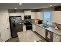 Bright kitchen with white cabinets, stainless steel appliances, and a granite countertop island, perfect for cooking at 200 Mission Terrace Dr, Whiteland, IN 46184
