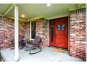 Inviting front porch with brick accents, comfortable rocking chairs, and a decorative butterfly door hanger at 201 Angela Ct, Noblesville, IN 46062