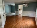 View of dining room with hardwood floors, elegant lighting, and access to the living room and kitchen at 213 Golf Ct, Greenwood, IN 46143