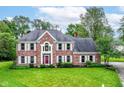 Beautiful two-story brick home with manicured lawn, mature trees, and classic architectural details at 3772 Christina Ct, Carmel, IN 46033