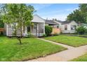 Cozy home with verdant lawn, mature tree, and convenient carport at 5473 E 18Th St, Indianapolis, IN 46218