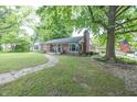 Charming brick home with mature trees and a stone walkway leading to the front door at 5601 Rosslyn Ave, Indianapolis, IN 46220