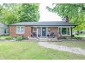 Charming brick home with a well-manicured lawn and inviting front porch at 5601 Rosslyn Ave, Indianapolis, IN 46220