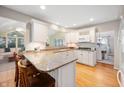 Bright kitchen with granite countertops, white cabinets, stainless steel appliances, and bar seating at 6020 Gladden Dr, Indianapolis, IN 46220