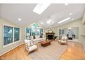 Bright living room featuring a vaulted ceiling, skylights, fireplace and large windows at 6020 Gladden Dr, Indianapolis, IN 46220