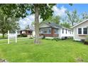 Beautifully maintained home featuring lush green lawn and mature trees, creating a serene setting at 6045 Dewey Ave, Indianapolis, IN 46219
