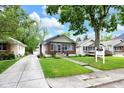 Quaint bungalow with manicured lawn, showcasing classic architectural details and welcoming curb appeal at 6045 Dewey Ave, Indianapolis, IN 46219