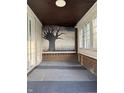 Inviting enclosed front porch features a tree mural and great natural light at 701 N Gladstone Ave, Indianapolis, IN 46201