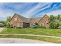 Beautiful brick home boasts mature trees, a well-manicured lawn, and classic design at 7093 Republic Ln, Indianapolis, IN 46259