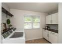 Well-organized laundry room with cabinets, countertop and washer and dryer at 713 Colonial Way, Greenwood, IN 46142
