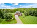 Expansive aerial view showcasing the charming brick home, lush greenery, and long driveway at 7333 State Road 42, Martinsville, IN 46151