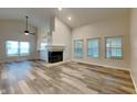 Open living room features vaulted ceilings, wood floors, and a cozy fireplace at 7859 Chesapeake E Dr, Indianapolis, IN 46236
