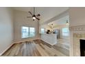 Bright living room featuring vaulted ceilings, wood floors, fireplace, and open kitchen view at 7859 Chesapeake E Dr, Indianapolis, IN 46236