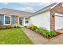 Close up of home showcasing manicured landscaping, brick accents, blue shutters, and a welcoming front entrance at 8684 Captain Dr, Avon, IN 46123